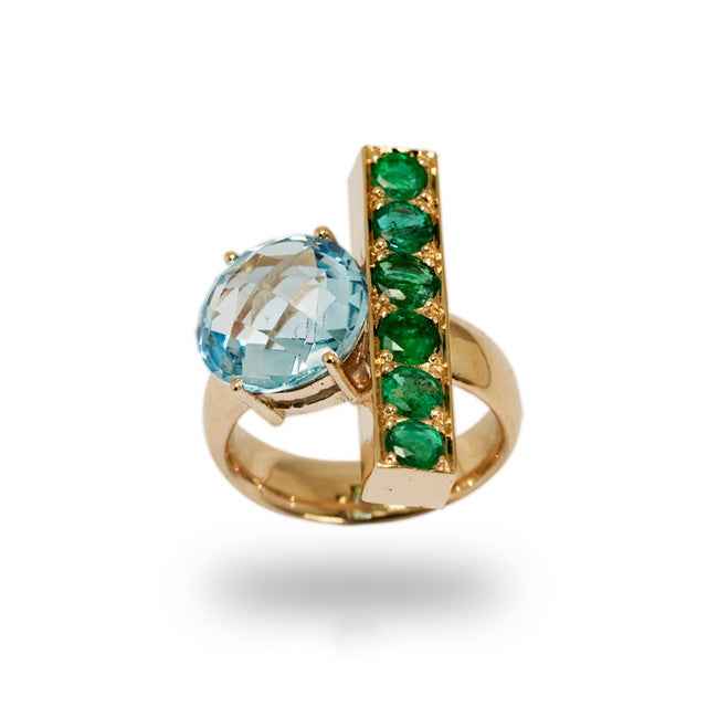 Anillo en oro rosa con topacio azul y esmeraldas